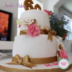 White cake with roses and gold bows