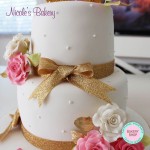 White cake with roses and gold bows